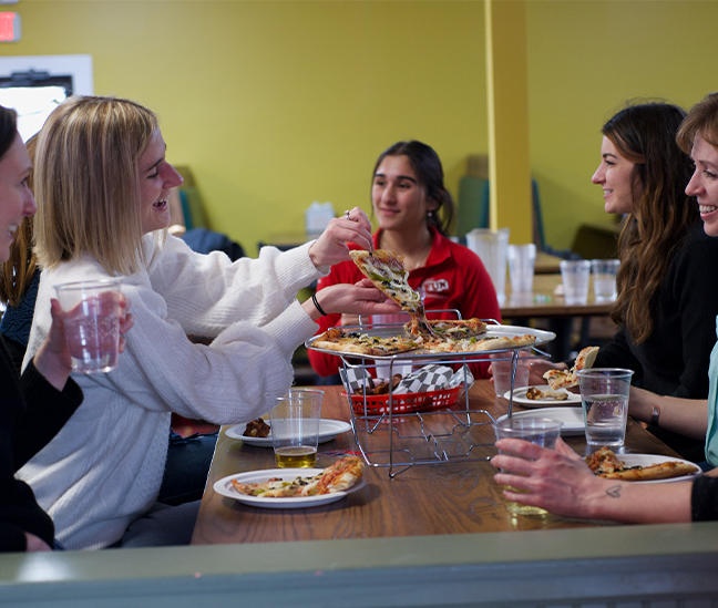 group photo enjoying pizza
