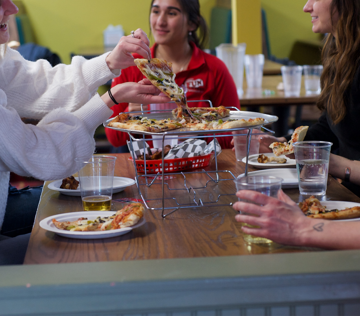 Group enjoying snack bar pizza