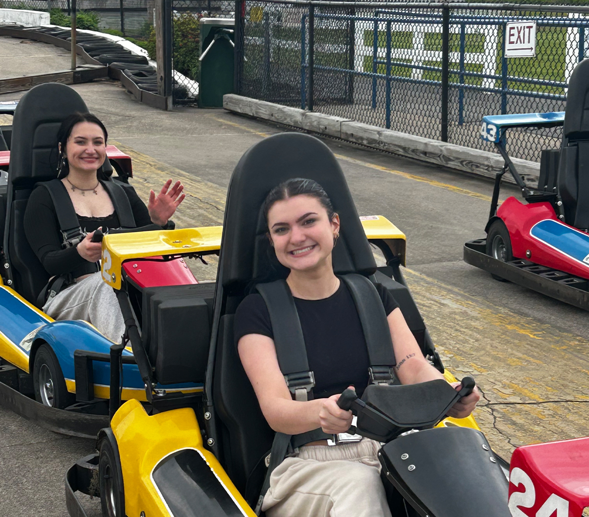 Teens in gokarts at funcenter on track.